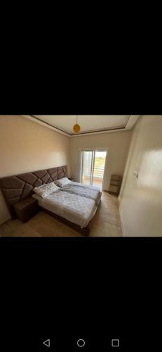 Un dormitorio con una cama grande y una ventana en Marina saidia en Oujda