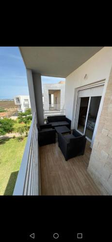 a balcony of a house with couches and a window at Marina saidia in Oujda