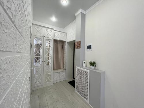um corredor com uma porta para um quarto com paredes brancas em Апартаменты в элитном ЖК em Pavlodar