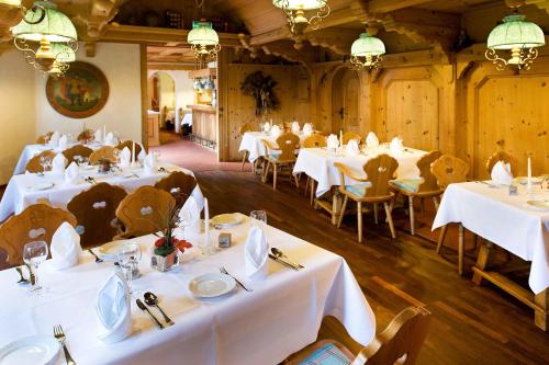 uma sala de jantar com mesas e cadeiras brancas em Hotel Westfalen Hof em Rahden