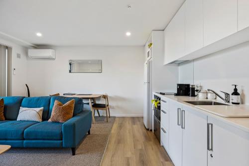 a living room with a blue couch in a kitchen at 1 Bedroom City Base with Free Car Park in Christchurch