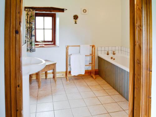 a bathroom with a tub and a sink at Mill Moor - B6064 in Pooley Bridge