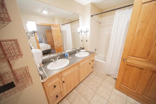 łazienka z 2 umywalkami i dużym lustrem w obiekcie Buffalo Lodge 8411 w mieście Keystone