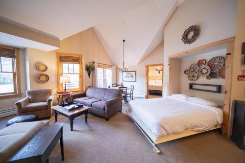 ein Schlafzimmer mit einem Bett und ein Wohnzimmer in der Unterkunft Buffalo Lodge 8411 in Keystone