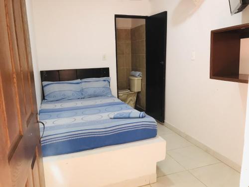 een kleine slaapkamer met een bed in een kamer bij Hostería Altamar Tolú in Tolú