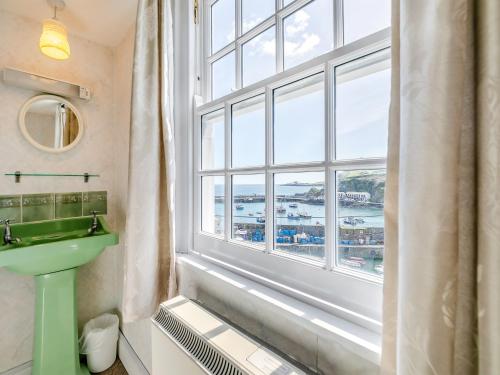 a bathroom with a sink and a large window at Memory Cottage in Mevagissey