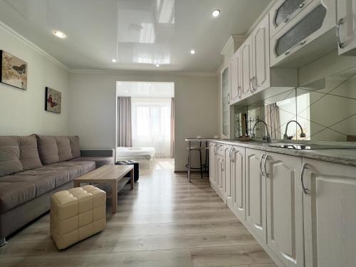 a living room with a couch and a kitchen at Квартира в элитном ЖК in Pavlodar