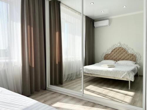 1 dormitorio con espejo y 1 cama en Квартира в элитном ЖК, en Pavlodar