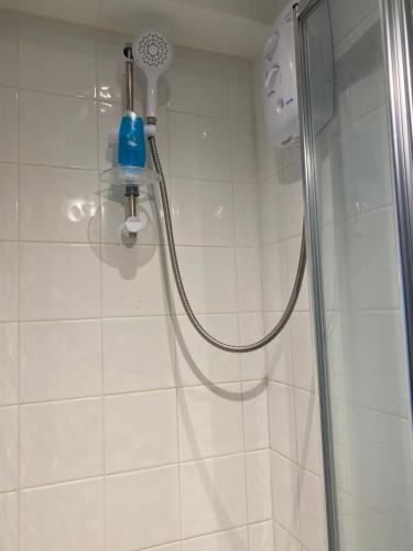 La salle de bains est pourvue d'une douche avec un pommeau de douche. dans l'établissement B Homestay, à Maidstone