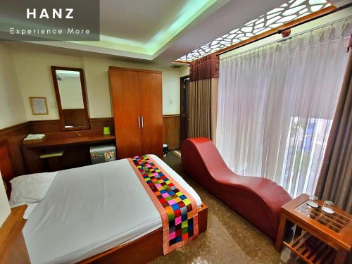 - une chambre avec un lit et une chaise rouge dans l'établissement HANZ Hien Lam Hotel, à Hô-Chi-Minh-Ville