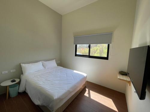 a bedroom with a white bed and a window at Islandlife B&B in Huxi