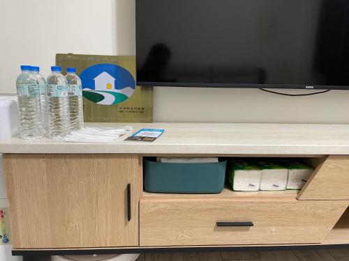 a desk with bottles of water and a television at Islandlife B&B in Huxi