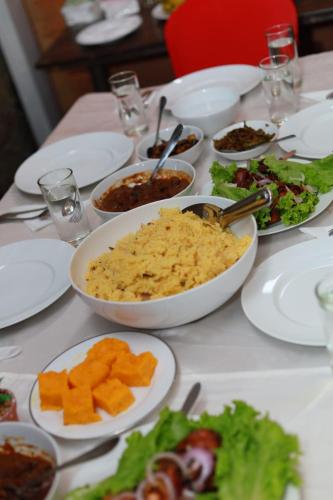 a table with white plates of food on it at Royal Apartments in Nuwara Eliya