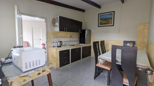 a kitchen with a table and a microwave at La casita in Cochabamba