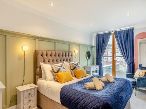 a bedroom with a large bed with yellow pillows at Harbourside Landing in Weymouth