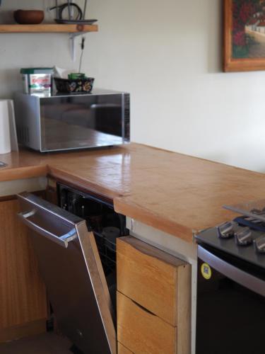 a kitchen with a wooden counter top with a microwave at Mystic Breeze in El Pescadero