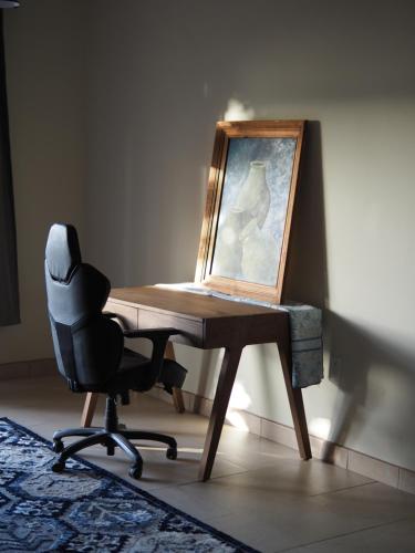 a desk with a chair and a painting on it at Mystic Breeze in El Pescadero