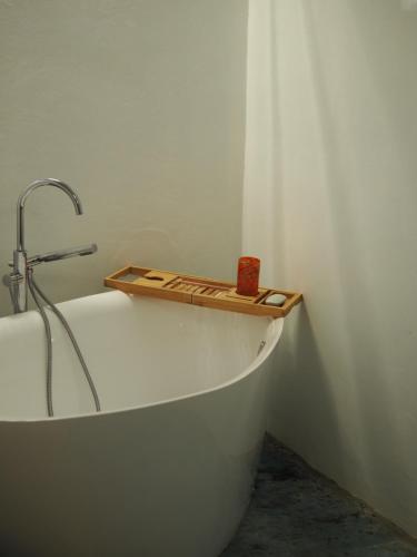 La salle de bains est pourvue d'une baignoire et d'un plateau en bois. dans l'établissement Mystic Breeze, à El Pescadero