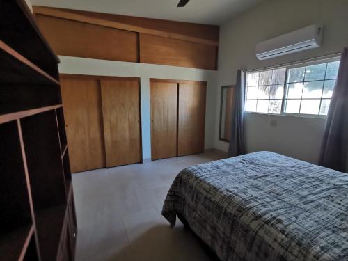 a bedroom with a bed and wooden cabinets and a window at Mystic Breeze in El Pescadero