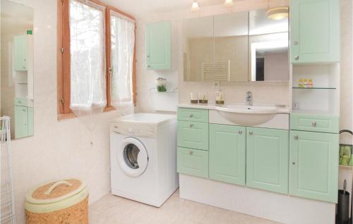 ein Badezimmer mit einer Waschmaschine und einem Waschbecken in der Unterkunft Gorgeous Home In Les Salles Du Gardon With Private Swimming Pool, Can Be Inside Or Outside in Les Salles-du-Gardon