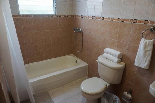 y baño con aseo, bañera y lavamanos. en Hermoso Apartamento Cerca de la Embajada Americana, en Santo Domingo