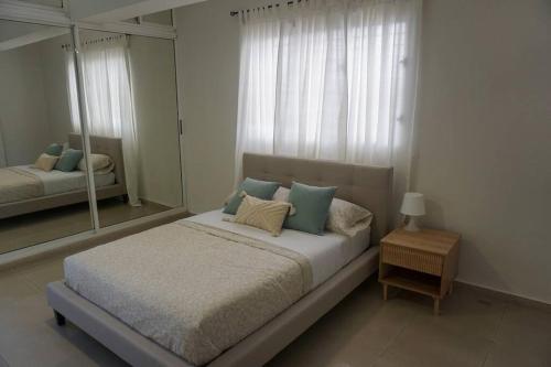 um quarto com uma cama grande e um espelho em Hermoso Apartamento Cerca de la Embajada Americana em Santo Domingo