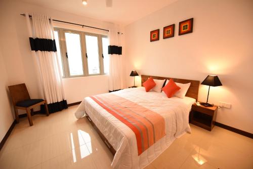 a bedroom with a large bed and a window at OnThree20 Araliya Apartment Colombo in Colombo