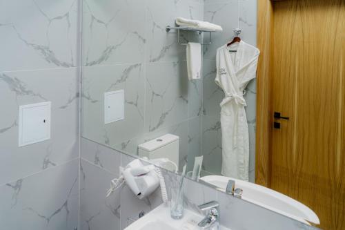 a bathroom with a sink and a mirror at Graf Hotel in Shymkent