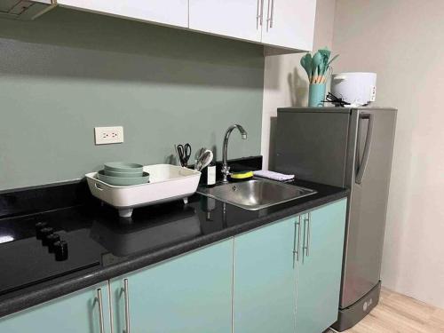 a kitchen counter with a sink and a refrigerator at 2 BR Condo Jazz cozy at best deal! in Manila