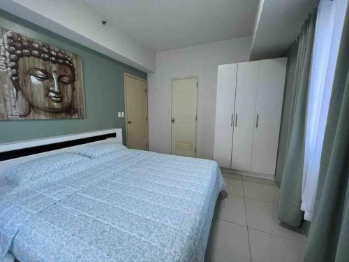 um quarto com uma cama com uma máscara na parede em 2 BR Condo Jazz cozy at best deal! em Manila