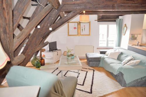 un salon avec un canapé bleu et une table dans l'établissement L'APPARTEMENT, à Colmar