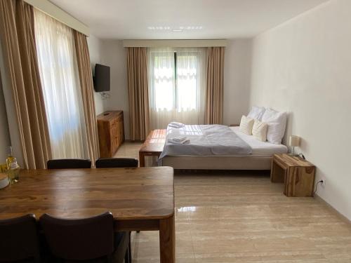 ein Hotelzimmer mit einem Bett, einem Tisch und Stühlen in der Unterkunft Penzion Za radnicí in Valtice