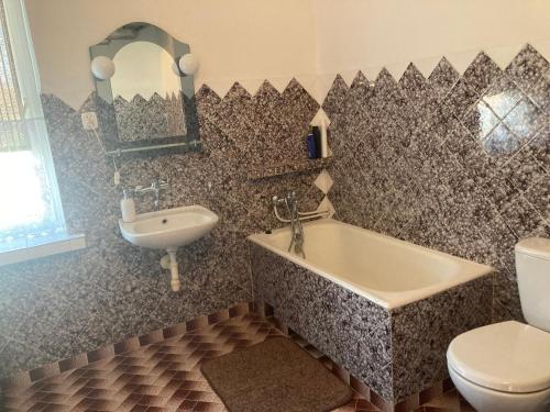uma casa de banho com um WC, uma banheira e um lavatório. em Apartament Villa Olivia em Szczebrzeszyn
