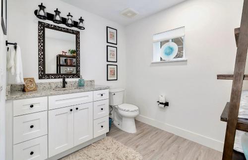 a white bathroom with a toilet and a mirror at Florida Short and Seasonal townhouses in Bradenton