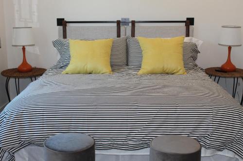 a bed with black and white striped sheets and yellow pillows at Florida Short and Seasonal townhouses in Bradenton