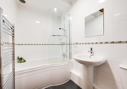 ein weißes Badezimmer mit einem Waschbecken, einer Badewanne und einer Dusche in der Unterkunft Stabal y Gelli in Trawsfynydd