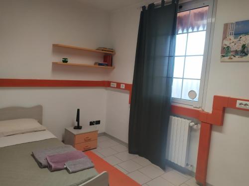 Habitación pequeña con cama y ventana en La Quiete, en Senna Comasco