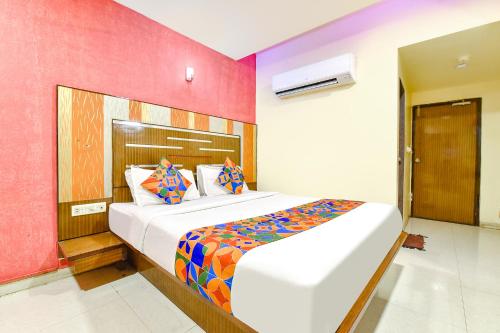 um quarto com uma cama grande e uma parede colorida em FabHotel Kadamb Inn em Ahmedabad