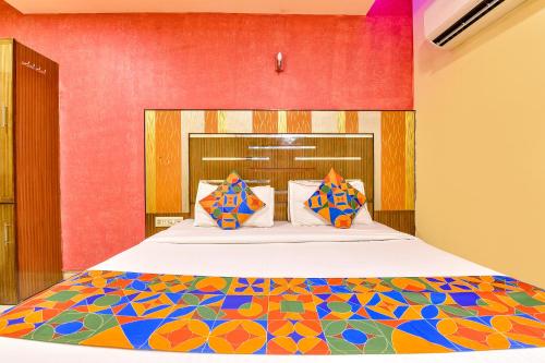 a bedroom with a large bed with a colorful bedspread at FabHotel Kadamb Inn in Ahmedabad