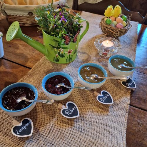 a table with three bowls of preserves and a vase of flowers at B&B Santa Brigida in Santa Brigida