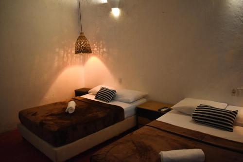 a bedroom with two beds and a light fixture at Casa Gaitana - Alma Hotels in Santa Marta