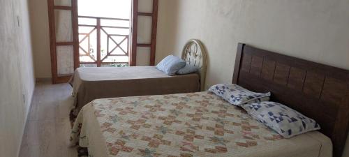 a bedroom with two beds and a quilt at Casa Moreira´s Chalés in Monte Verde