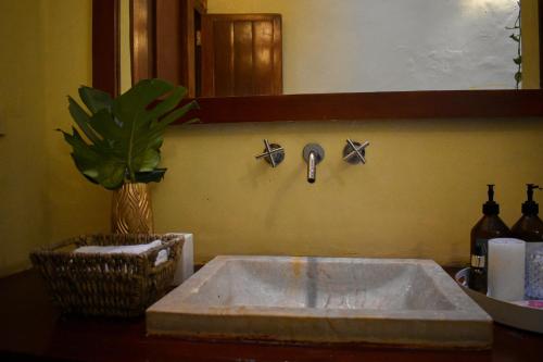 umywalka w łazience z kranem na ścianie w obiekcie Casa Gaitana - Alma Hotels w mieście Santa Marta