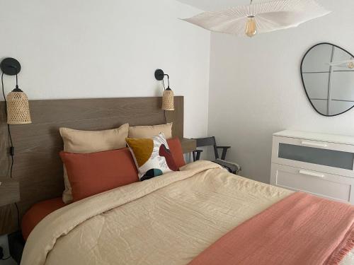 - une chambre avec un lit doté d'oreillers et d'un miroir dans l'établissement BIKINI, à Cavalaire-sur-Mer