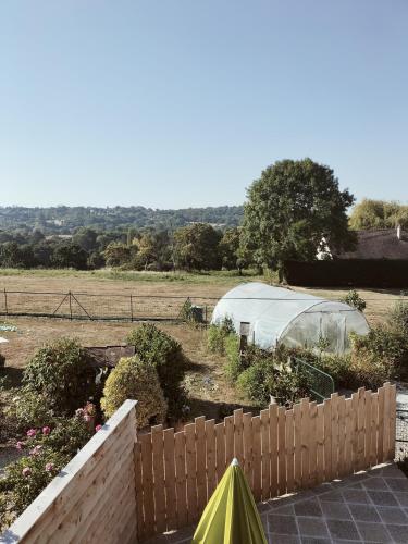 a garden with a tent and a fence at A deux pas de Cabourg ,avec une belle vue sur la campagne normande.A grangues in Grangues