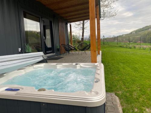 a hot tub sitting outside of a house at Tiny House by the forest 1 