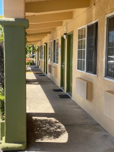 an empty hallway of a building with green columns at Holiday Motel in Morgan Hill