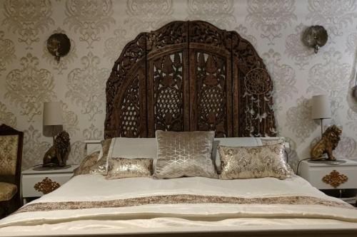 a large bed with a wooden headboard in a bedroom at Kaunis omakotitalo Sahalahdessa 