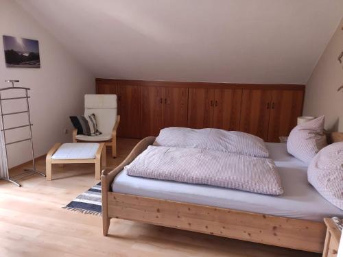 a bedroom with a bed and a chair at Ferienwohnungen Kral in Grainau