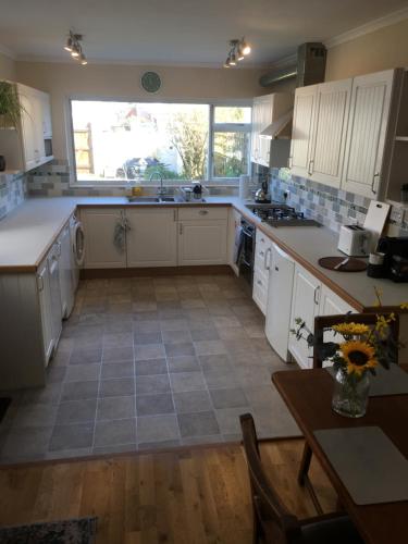 a kitchen with white cabinets and a large window at The Anchorage , Gorleston on Sea in Gorleston-on-Sea